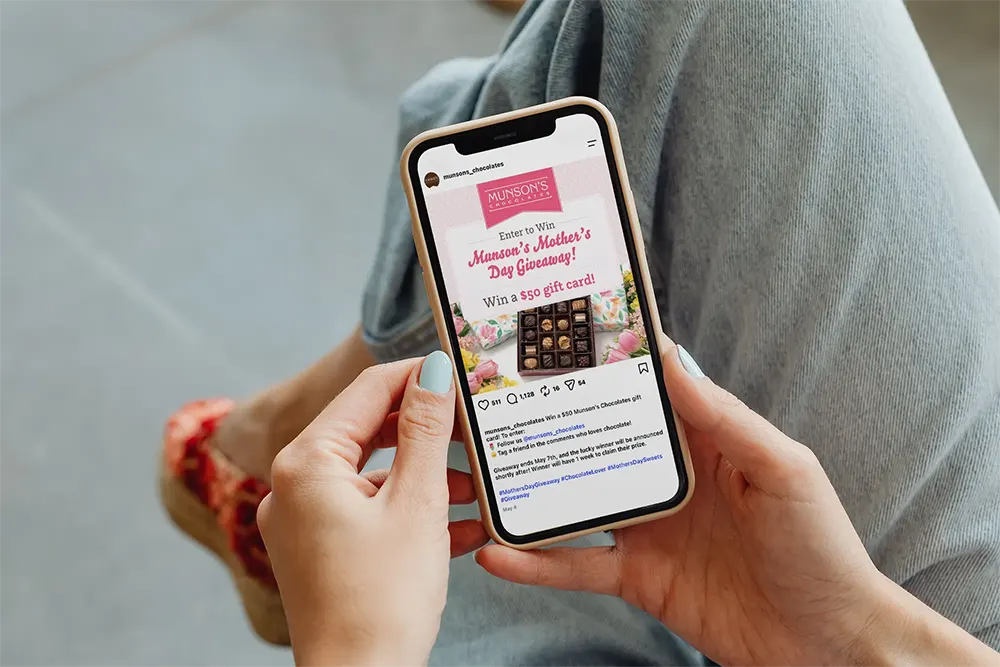 Person viewing a smartphone displaying a holiday marketing campaign for a chocolate company.