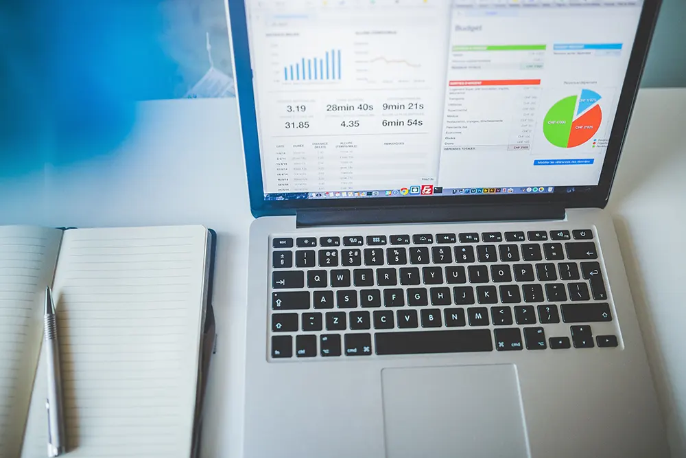 Laptop screen showing strategic marketing data and notebook.
