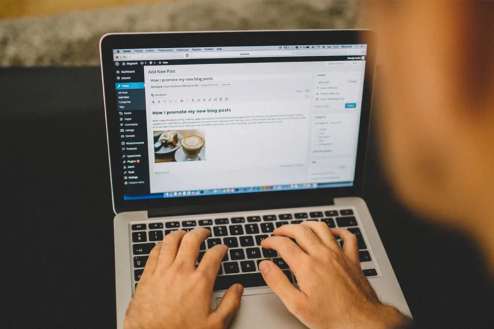 Person creating web content on a laptop.