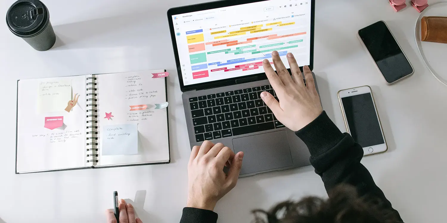 Person pointing at a laptop screen displaying a content strategy calendar.