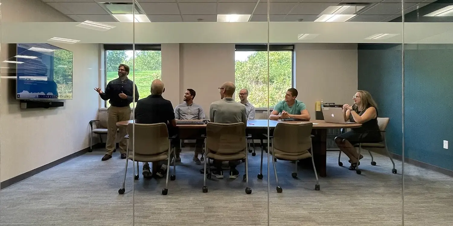 Person providing email marketing training to a group of people in a conference room.