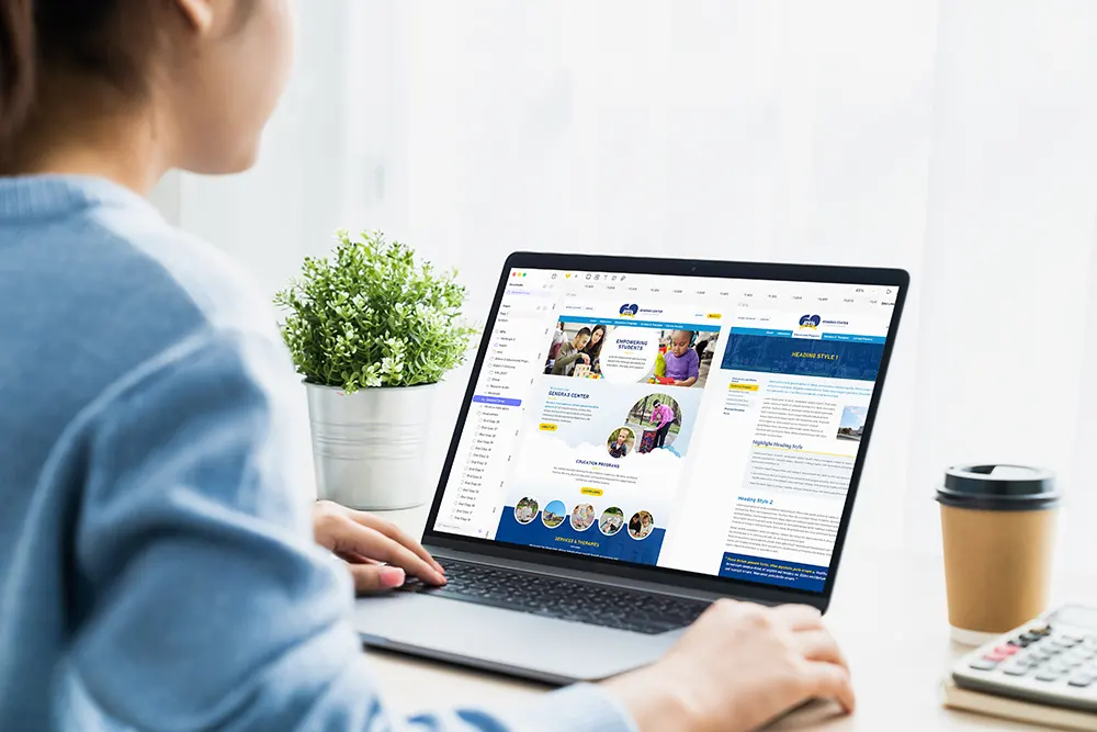 Person designing a website on a laptop.